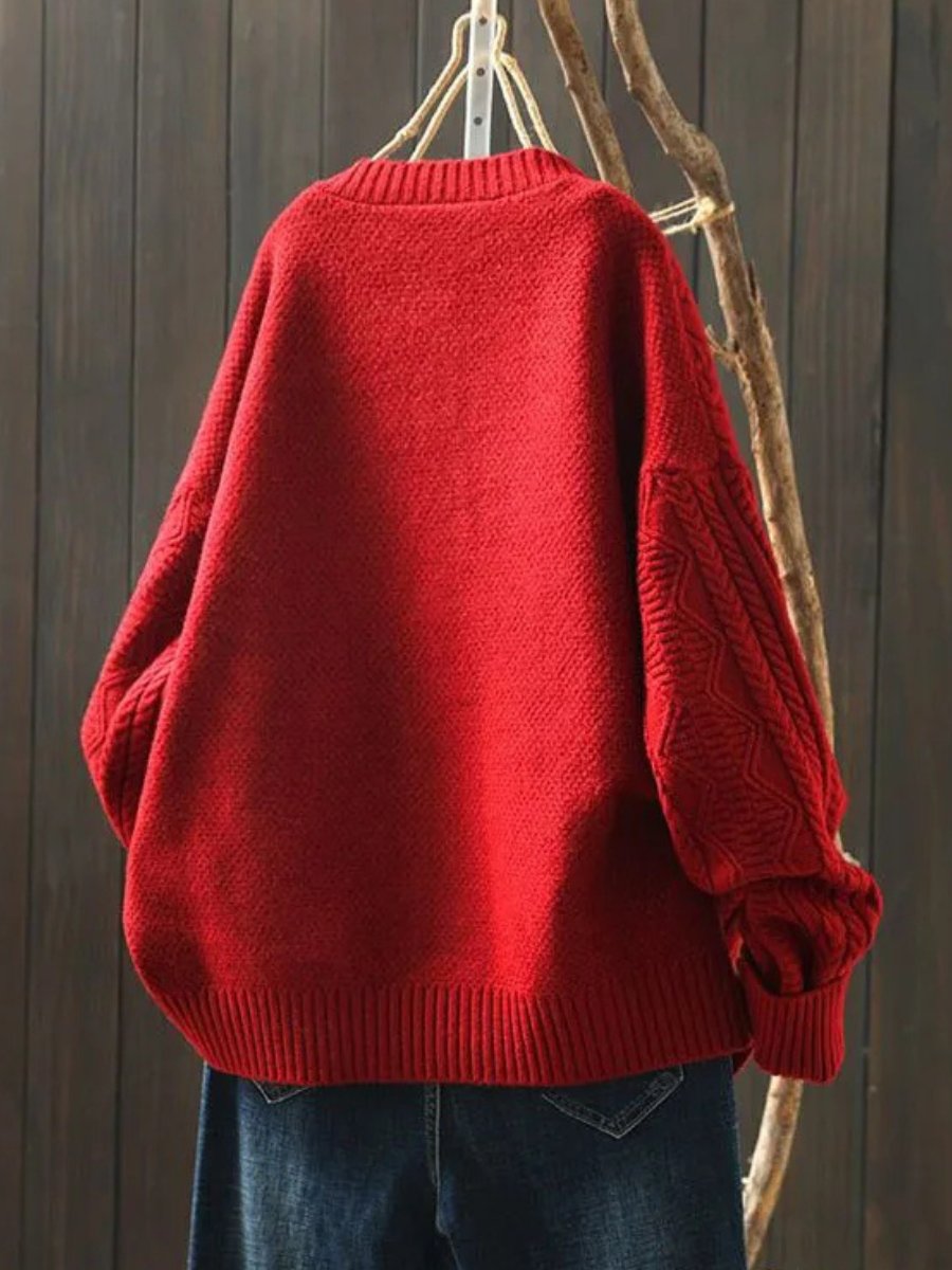 Red oversized cable knit sweater with wide sleeves and ribbed hem
