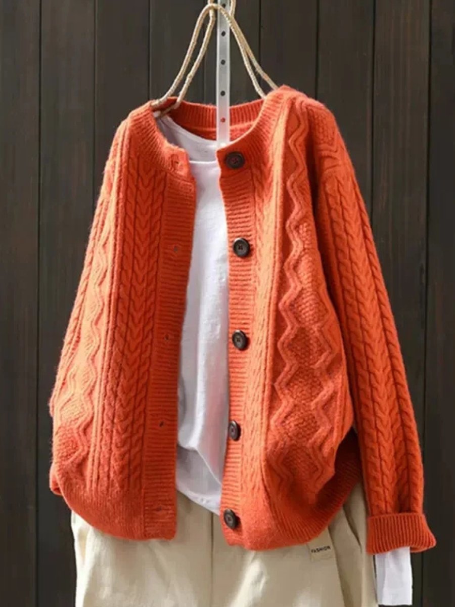 Orange oversized cable knit cardigan with button front and cable pattern sleeves