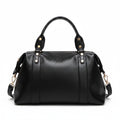 Black leather-style Boston handbag with top handles, gold hardware, and side tassel details.