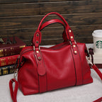 Red leather-style Boston handbag with two handles, gold hardware, and a removable shoulder strap.