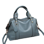 Blue leather-style Boston handbag with top handles, gold-tone eyelets, and side zipper pull tabs.