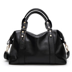 Black leather-style Boston handbag with top handles, gold hardware, and shoulder strap.