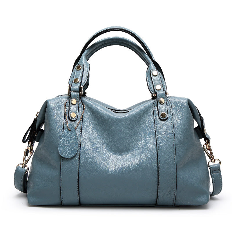 Light blue leather-style Boston handbag with top handles and gold-tone eyelets.