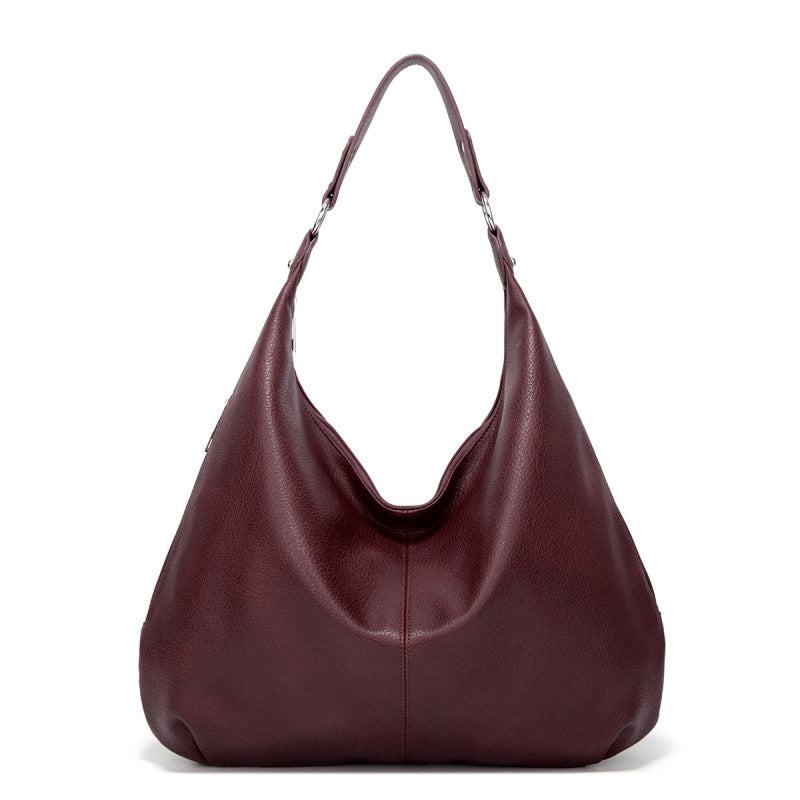 Burgundy textured leather hobo bag with two top handles and open curved front.