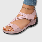 Pink strappy sandals with adjustable hook-and-loop straps and cushioned sole