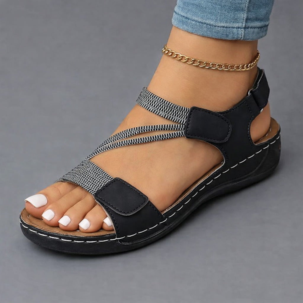 Black strappy sandals with adjustable hook-and-loop straps and cushioned platform sole
