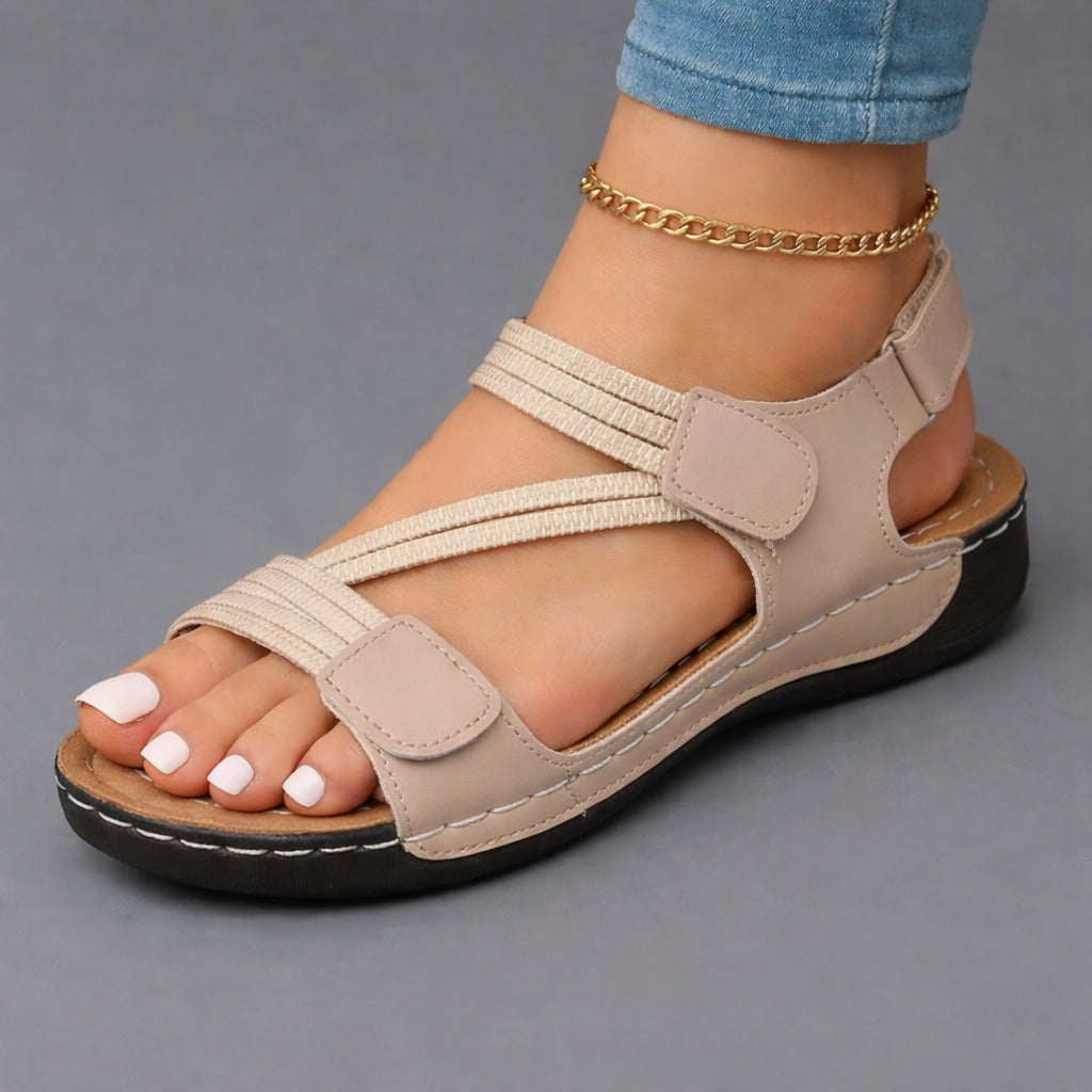 Beige strappy sandals with adjustable hook-and-loop straps and cushioned sole