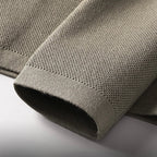 Beige blazer cuff close-up with woven texture and hem finish