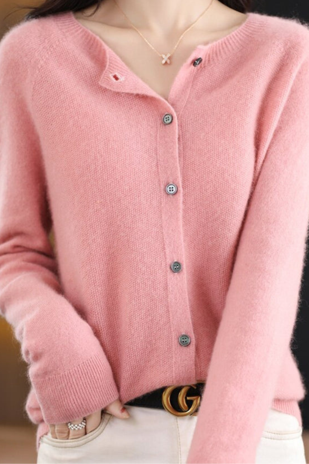 Women’s light pink V-neck button cardigan close-up with dark buttons
