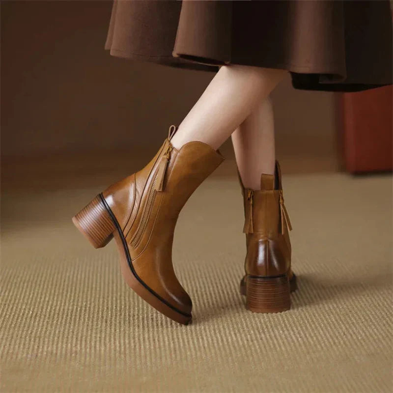 Brown ankle boots with side zipper and block heel, worn with a dress