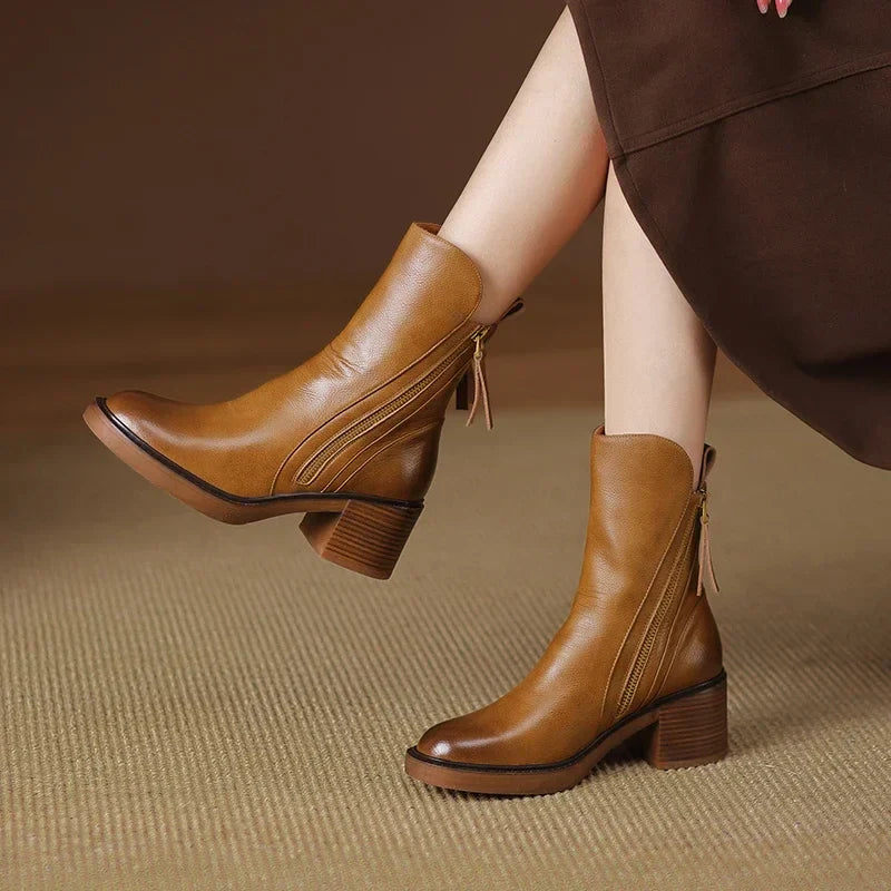Brown ankle boots with side zipper and block heel, angled view on model