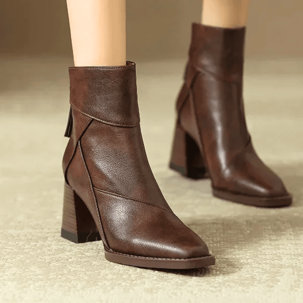 Brown ankle boots with block heels, side tassel pull, and angled seam panels