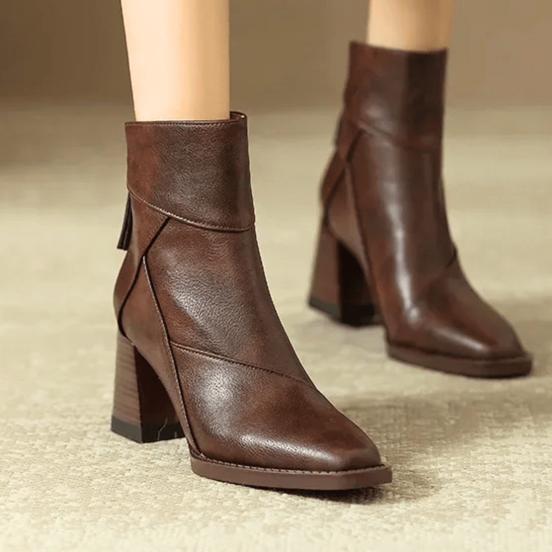 Brown ankle boots with block heels, side tassel pull, and angled seam panels