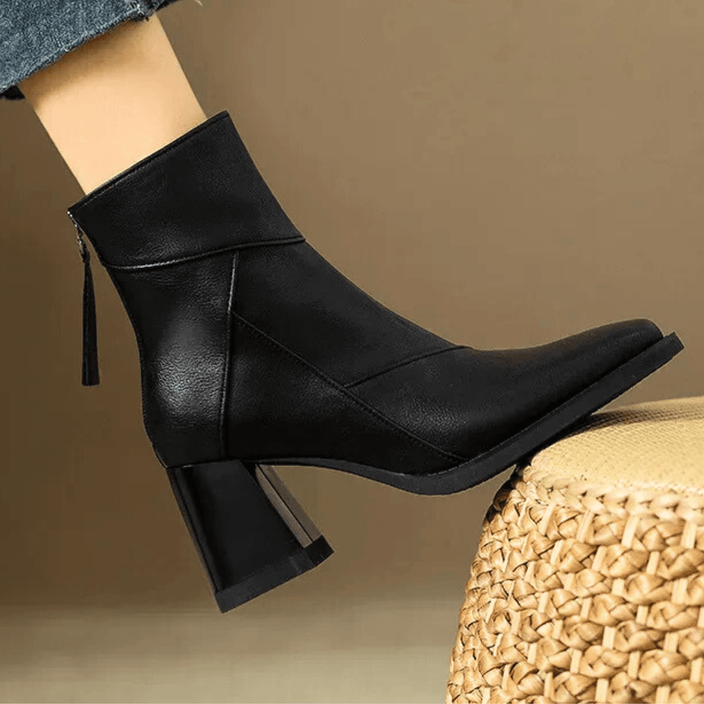 Black ankle boots with block heels, diagonal stitching, and side tassel pull