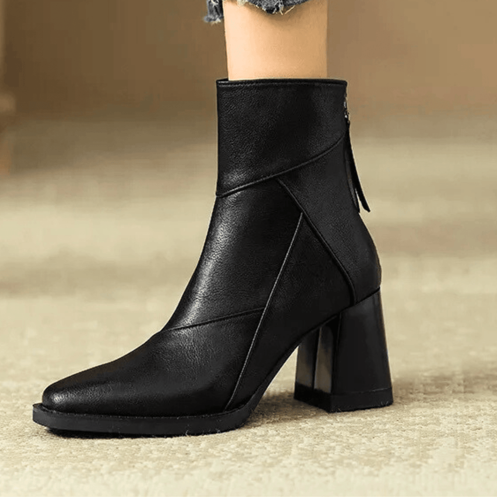 Black ankle boots with block heel, diagonal seam and small side tassel detail