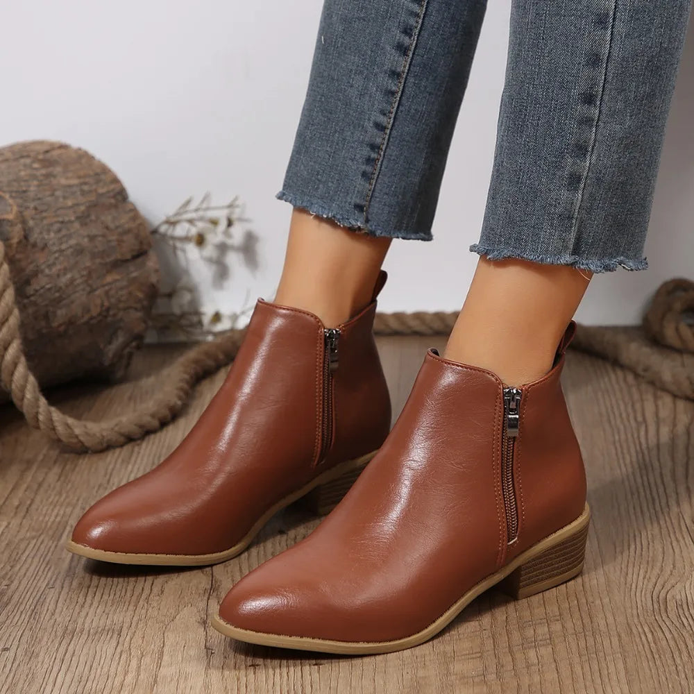 Women’s brown ankle boots with side zipper, tan sole edge, and low block heel