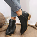 Women’s black ankle boots with side zipper and tan sole, styled with cropped jeans