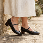 Black Mary Jane block heels with ankle strap and glossy round toe.