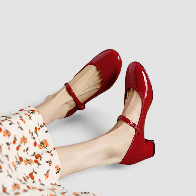 Red Mary Jane pumps with ankle strap and rounded toe, side view