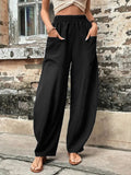 Relaxed wide-leg palazzo trousers in black with elastic waist and roomy drape