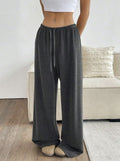 Dark gray wide-leg sweatpants with elastic waistband and drawstring, full length