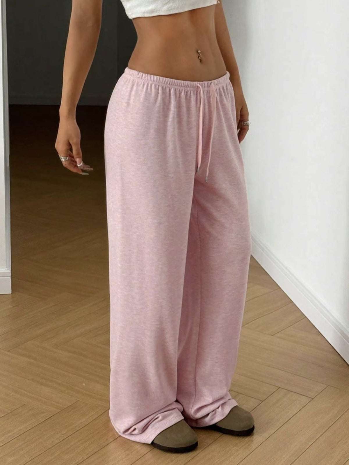 Pink wide-leg sweatpants with elastic waistband and drawstring, relaxed drape