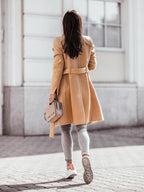 Beige women's belted trench coat back view, long sleeves, double-breasted detail