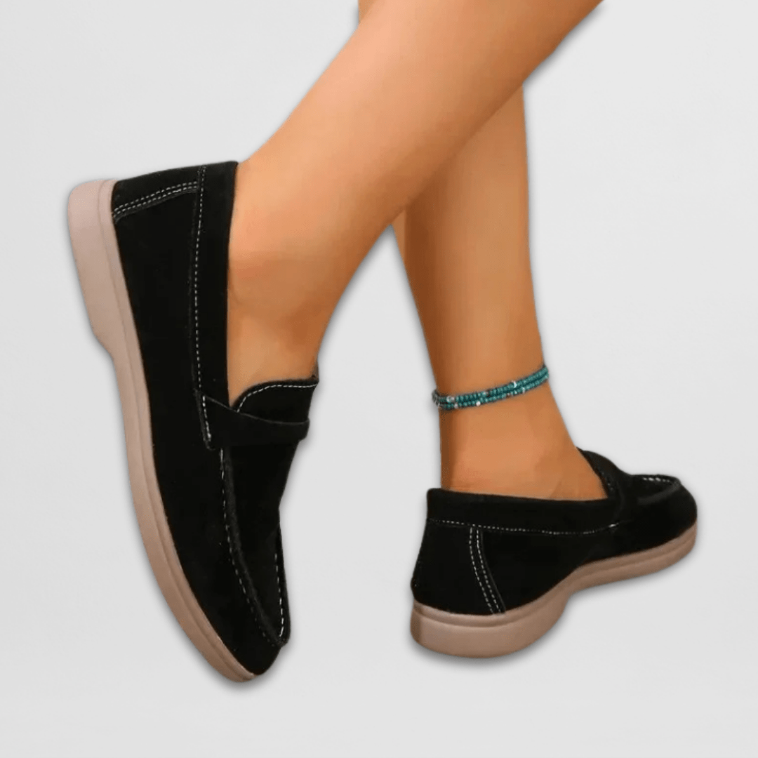 Black women's suede slip-on loafers with round toe, side stitching, and flat sole