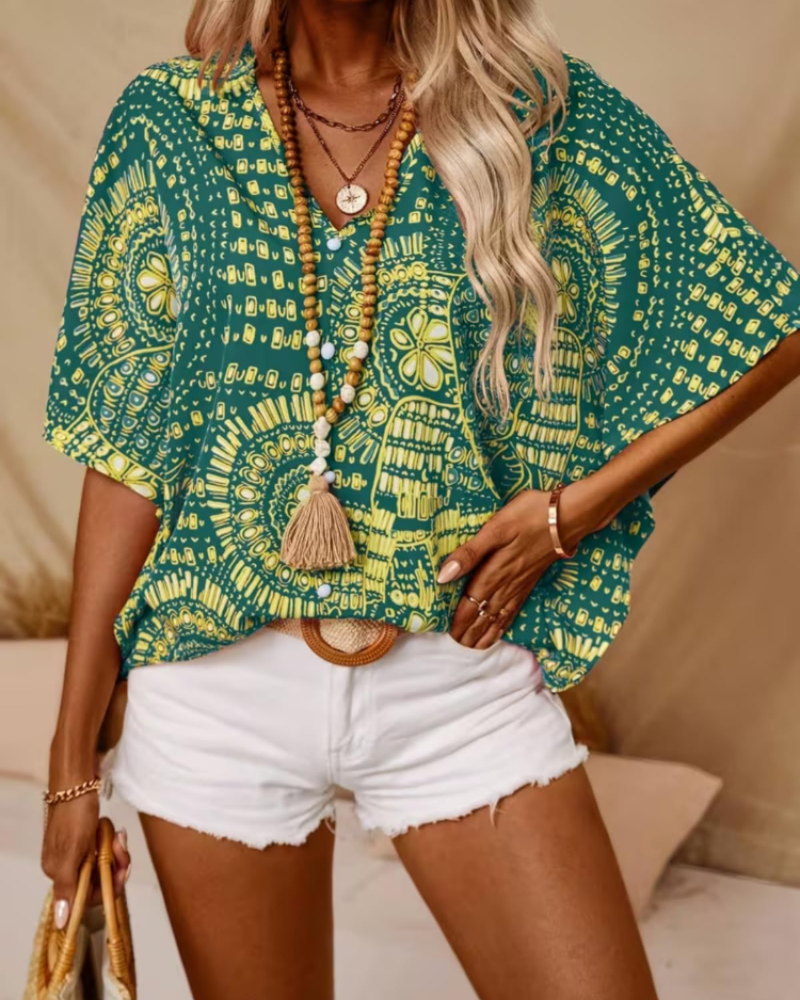 Green oversized boho tunic blouse with V-neck, short sleeves, ornate yellow print and tassel detail