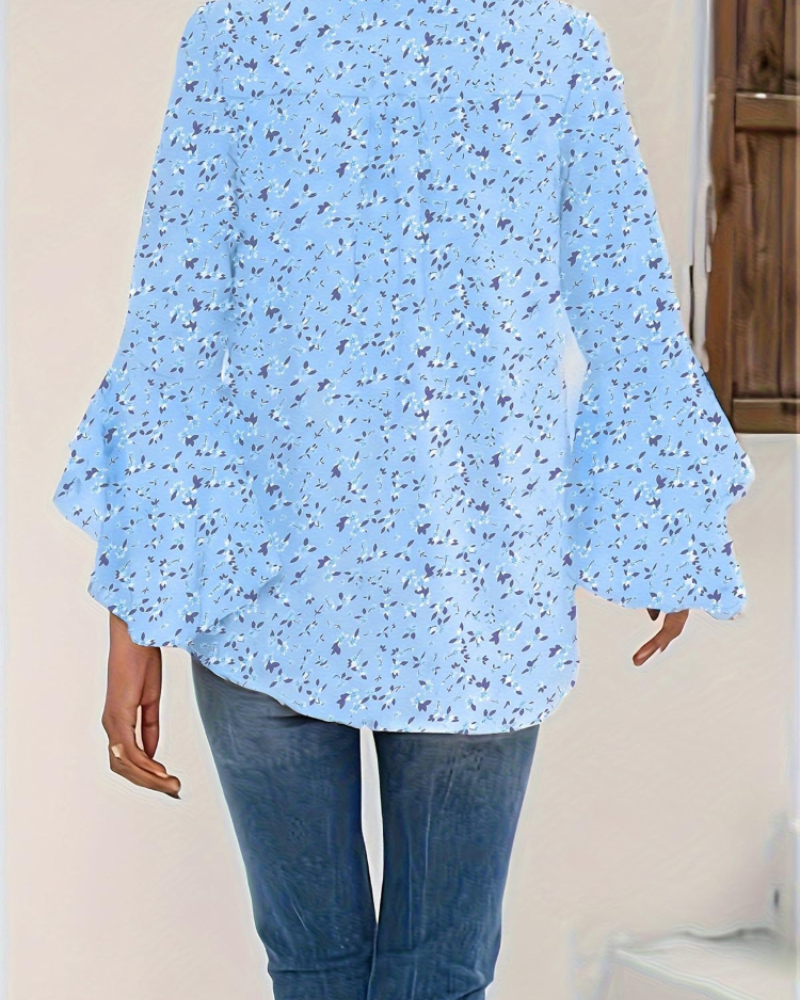 Light blue floral blouse with 3/4 bell sleeves and curved back hem