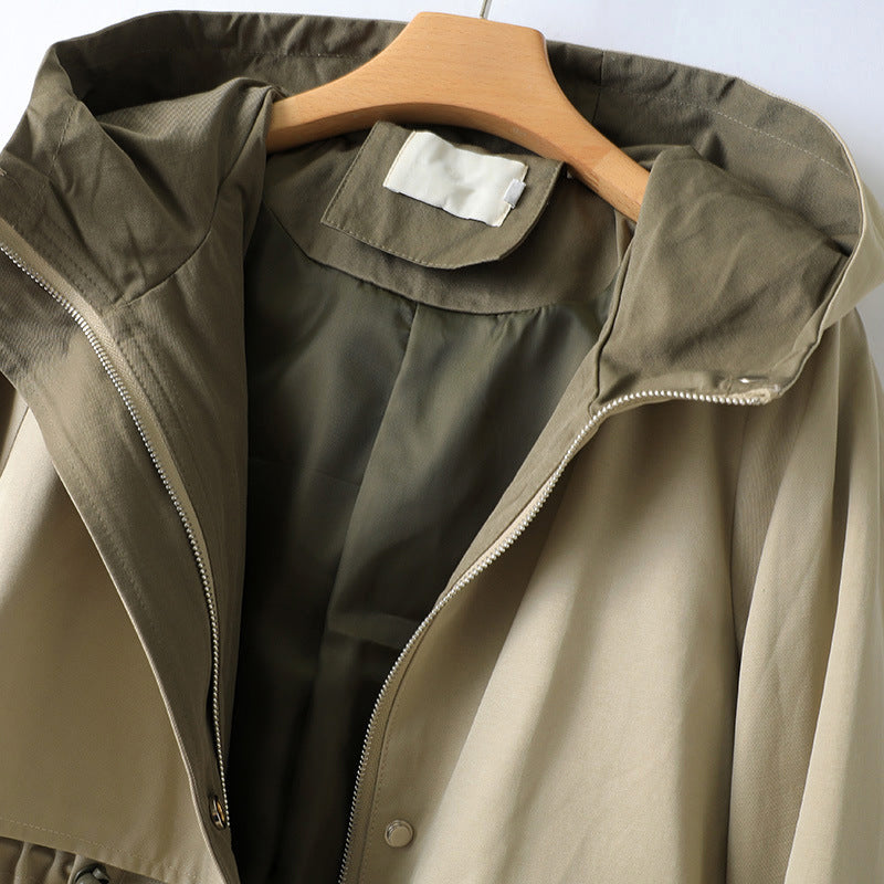 Green hooded waterproof trench coat close-up with zip placket and snap details