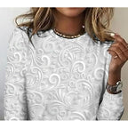 Pearl long-sleeve tunic close-up with embossed floral scroll pattern across chest