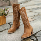 Tan knee-high western boots with embroidered panels and side pull tab on shaft.