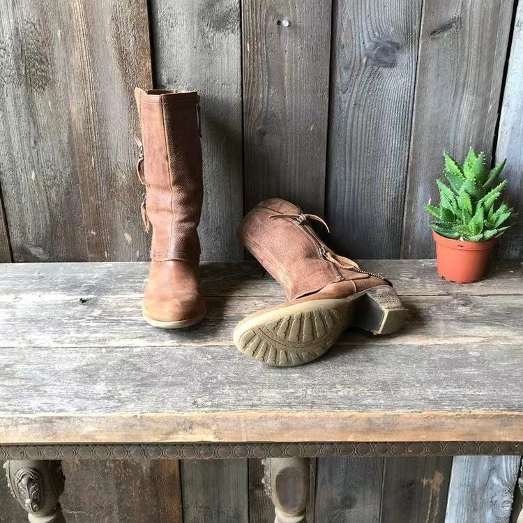 Brown mid-calf boots with side zips; one boot on the ground showing outsole
