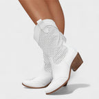 White mid-calf boots with perforated side panels and buckle strap detail