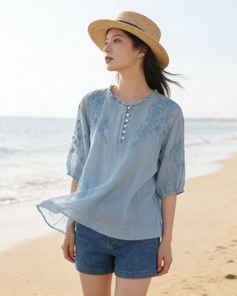 Light blue embroidered cotton blouse with puff sleeves and henley-style buttons