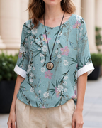 Lightweight floral blouse with round neck and short sleeves, teal floral print close-up