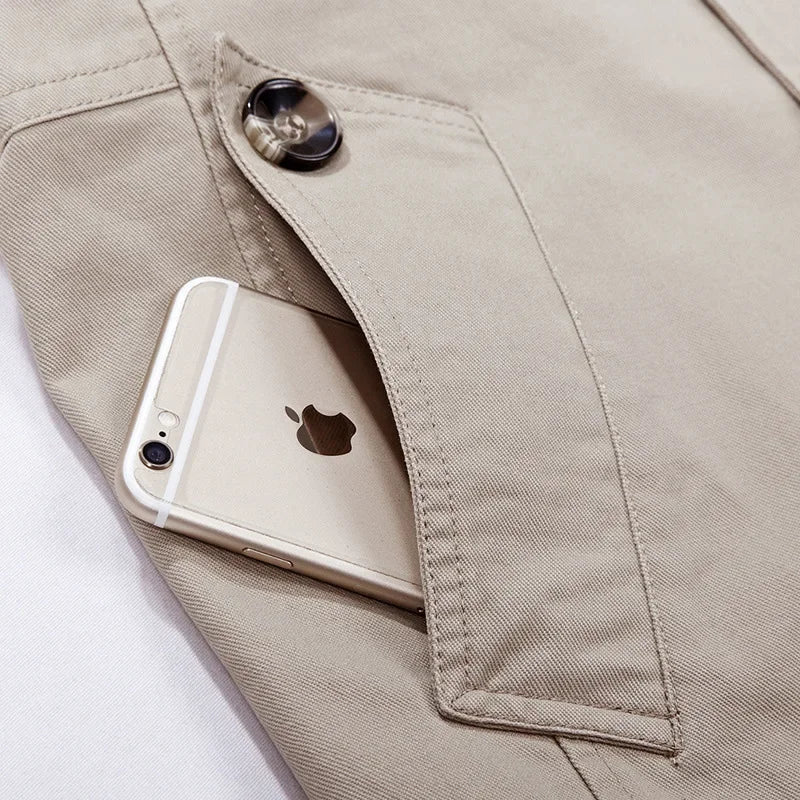 Beige hooded field coat close-up: snap button and front pocket detail.