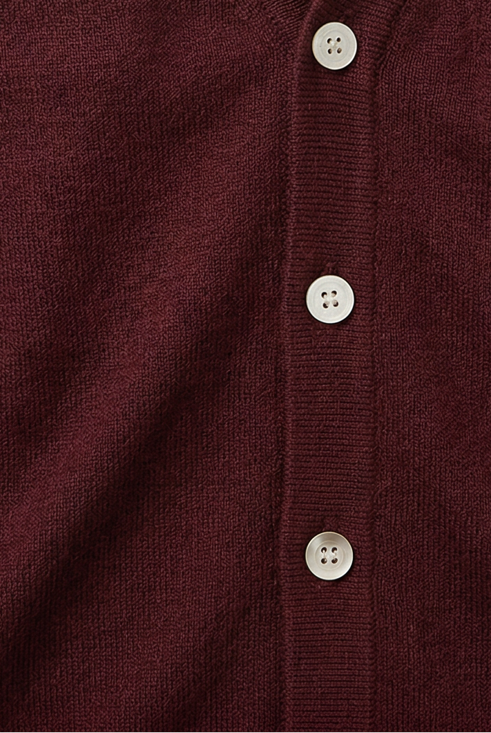 Burgundy knit cardigan button placket detail with three white buttons