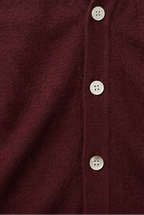 Burgundy knit cardigan button placket detail with three white buttons