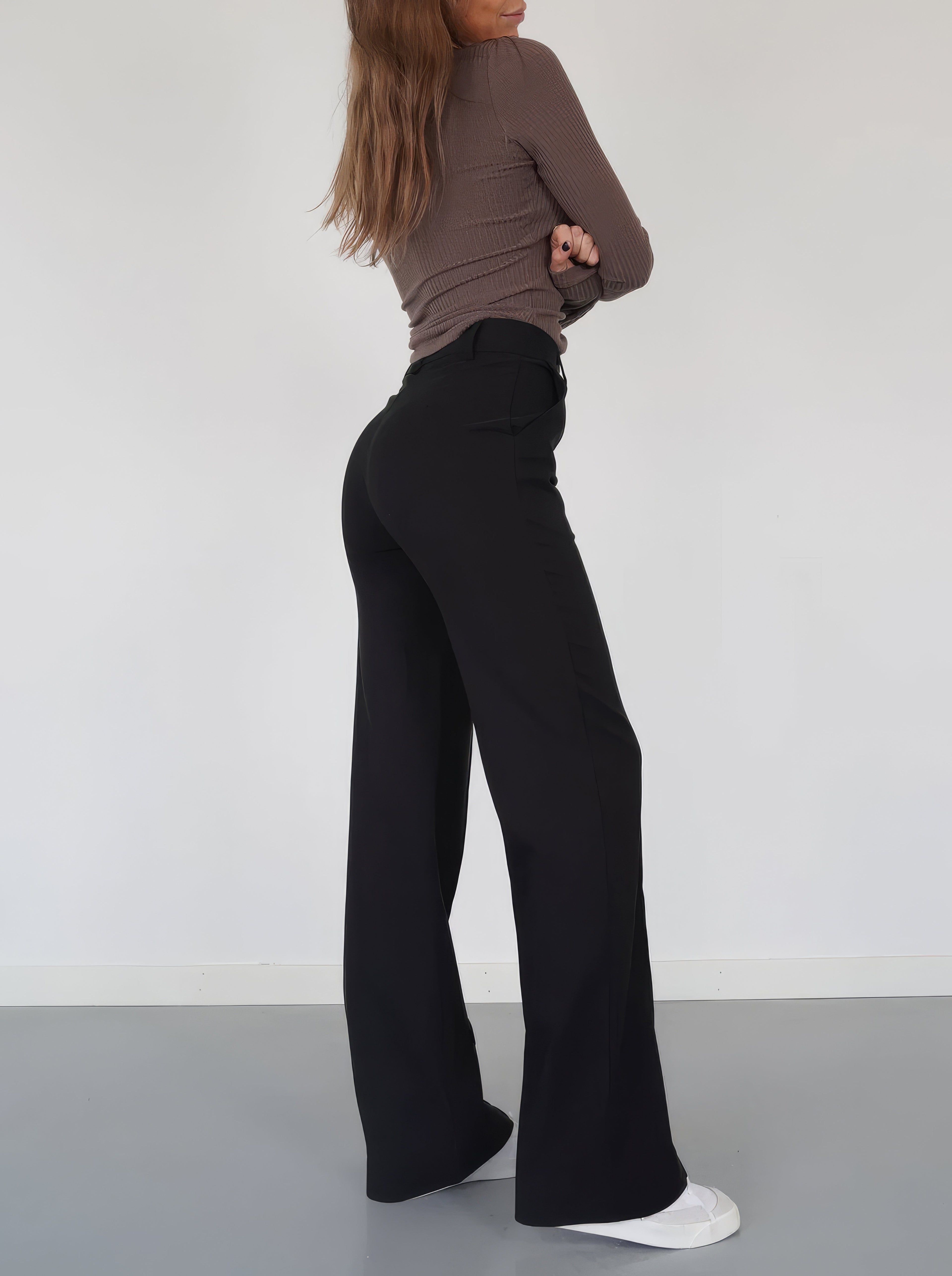 Black relaxed wide-leg trousers, side view showing wide, flowing leg opening