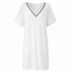 Women's white cotton V-neck shift dress with dark trim and short sleeves, patch pockets