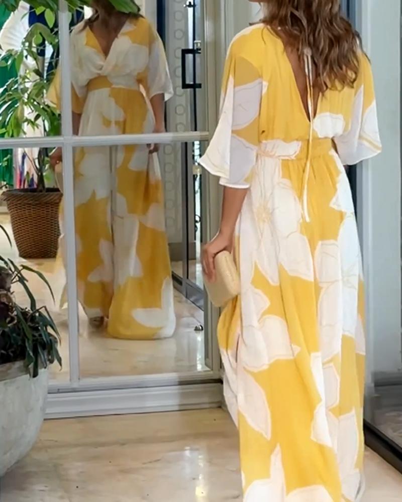 Yellow floral maxi dress with V-neck, flared skirt, and gathered waist detail