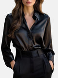 Black satin long-sleeve blouse with button front, pointed collar, and tie waist