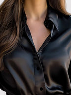 Black satin blouse close-up of pointed collar, open V-neck, and buttons