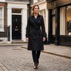 Black belted double-breasted trench coat with tailored waist, epaulettes, longline