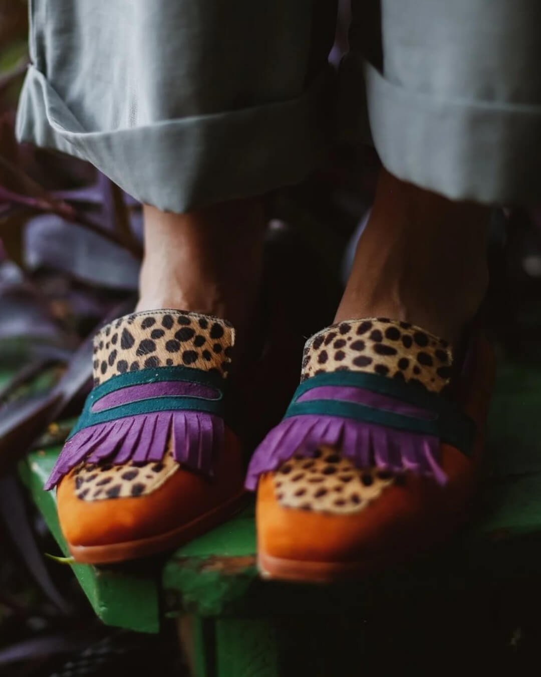 Brown animal-print leather loafers with purple fringe tassel and strap detail