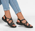 Black slip-on sandals with crisscross striped straps and open toe cushioned sole
