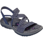 Blue slip-on sandals with striped crisscross straps and starburst detail on footbed