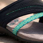 Close-up of navy thong flip-flop strap with teal patterned inlay and stitching